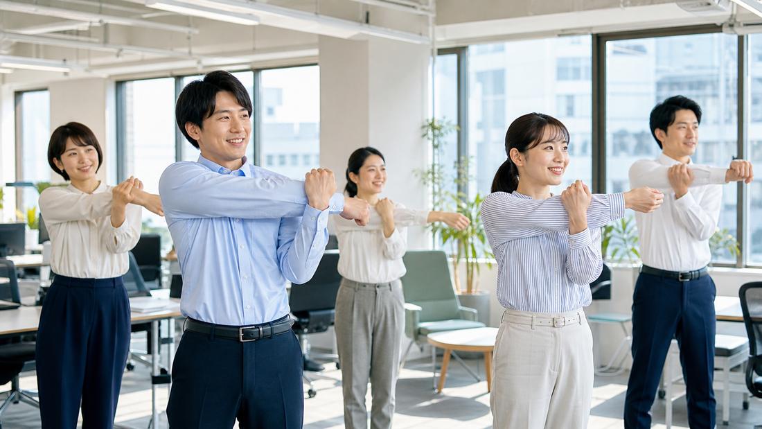 オフィスで朝礼ストレッチをする社員のイメージ